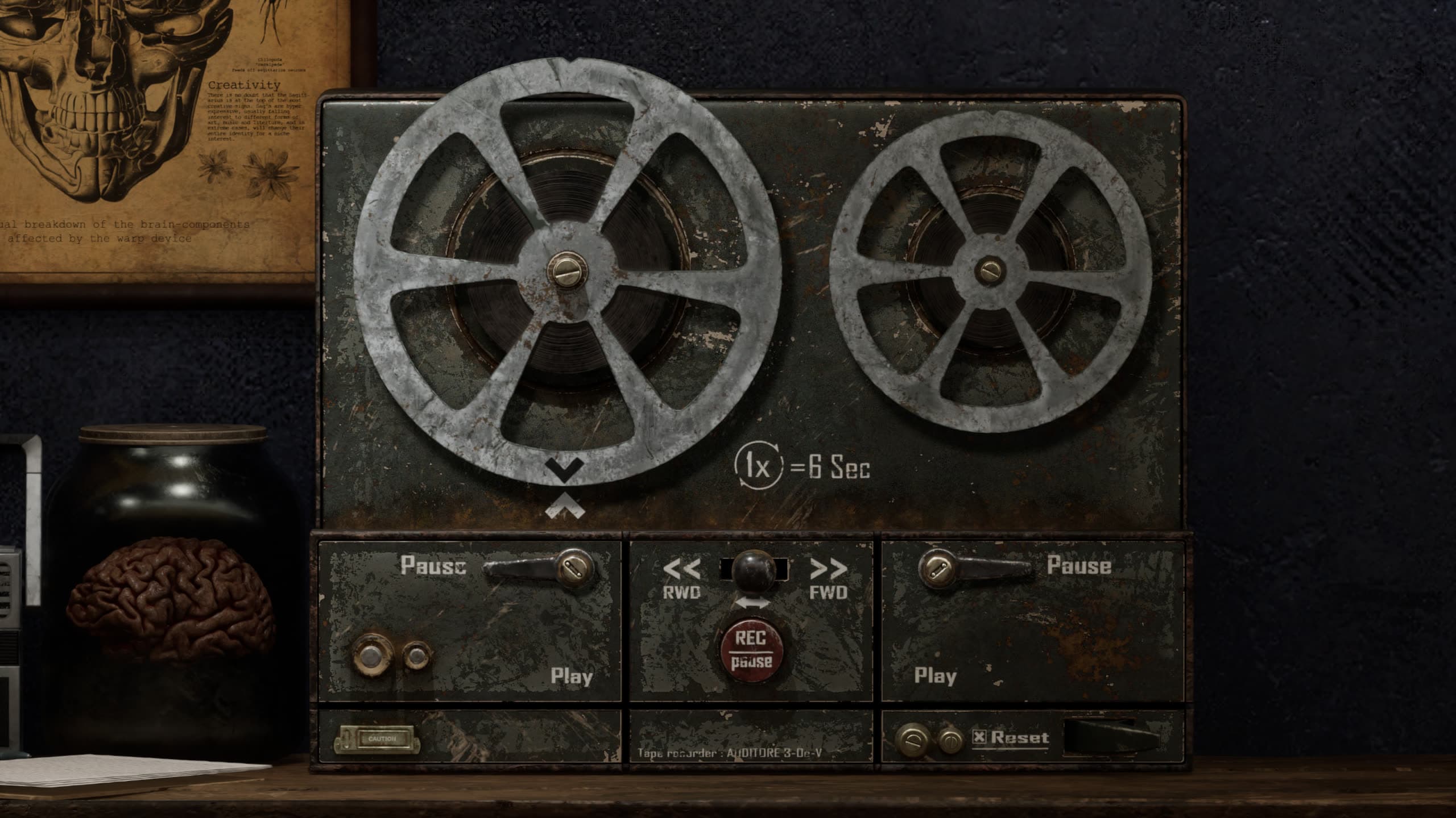 Reel-to-reel tape recorder on a desk beside a brain in a jar and an anatomical chart
